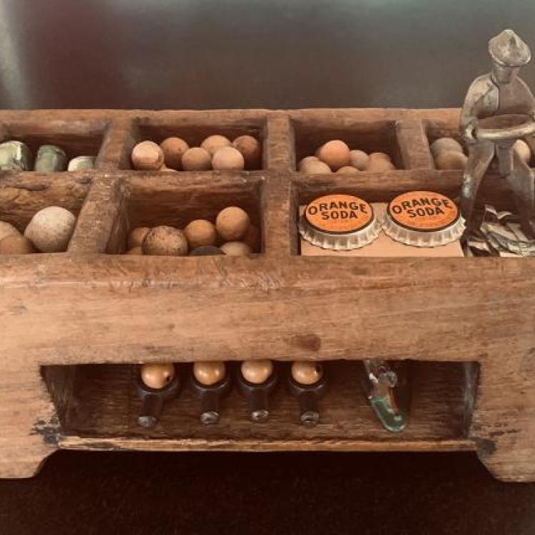 Richard Wilde - "The Difference Between Being Drivan and Driving" -A circa 1890 Indonesian wooden lunch box filled with assorted objects and a seated figure with a steering wheel - 4.5" x 10" x 7" height